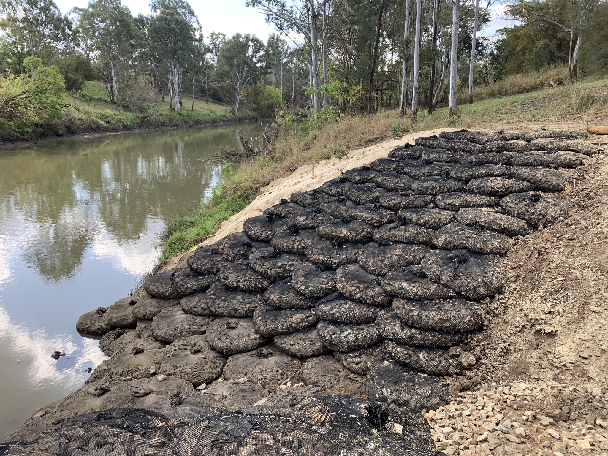 Rock Bag Filter Untis protecting tidal river bank with rock armouring and natural vegetation